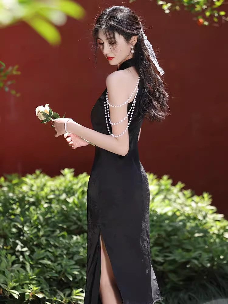 Black sleeveless cheongsam with pearl chain.