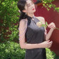 Black sleeveless cheongsam with pearl chain.