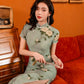 Green jacquard cheongsam. Knee qipao. Silk and polyester blend.